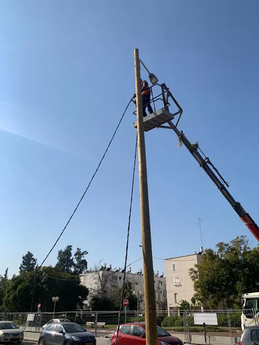 הסטת תשתית עילית: מנוף ועובד בסל הרמה מטפלים בעמוד לאורך התוואי.