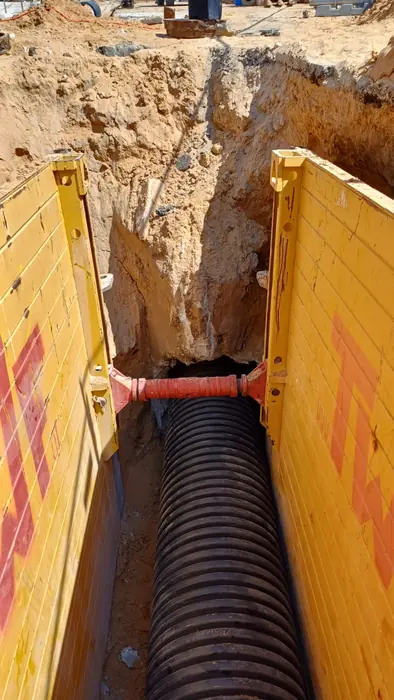 דיפון תעלה בלוחות מתכת, עם צינור ניקוז גלי מונח בקרקעיתה.