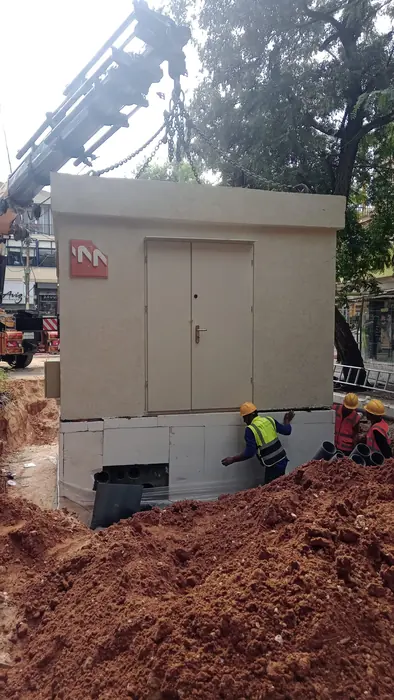 הצבת תא תשתית טרום במנוף, עם עובדים שמכוונים אותו למקומו.