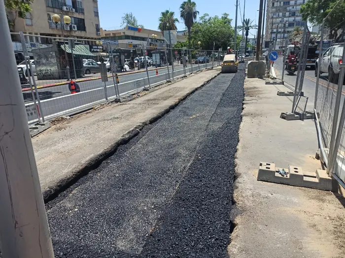 רצועת אספלט חדשה שנסללה לאורך התוואי, מגודרת מול הרחוב הפעיל.