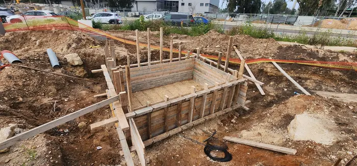 תבניות עץ ורשת זיון לתא בטון שנוצק באתר.