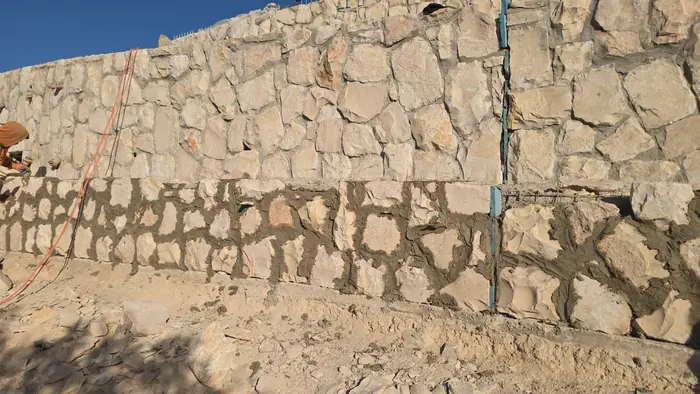 קיר אבן מוגמר בשתי שכבות בנייה לאורך גבול הפארק.